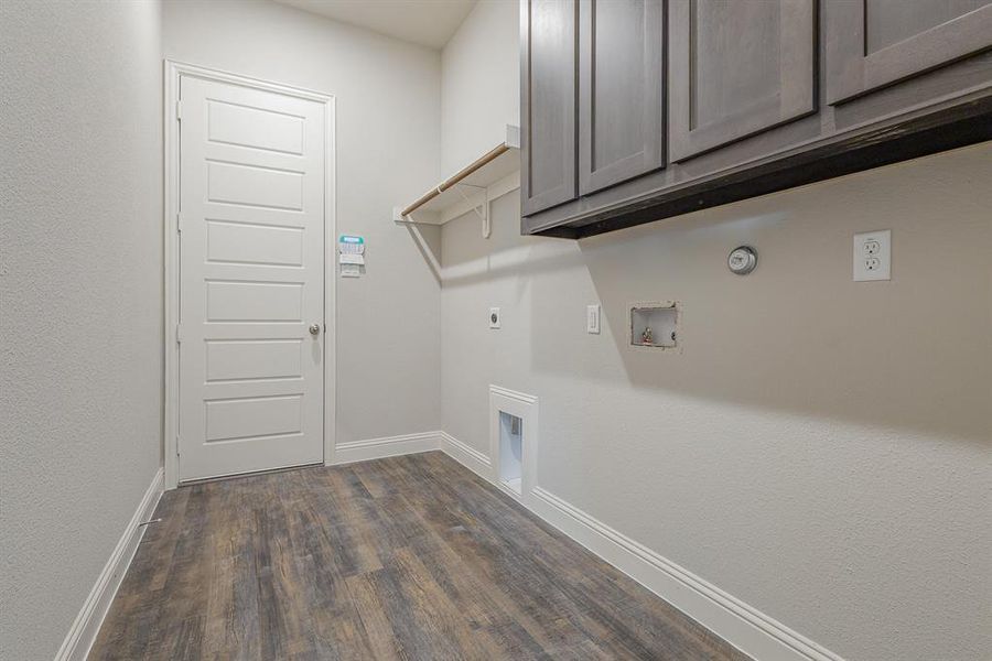 Clothes washing area featuring cabinets, hookup for an electric dryer, washer hookup, dark hardwood / wood-style floors, and gas dryer hookup