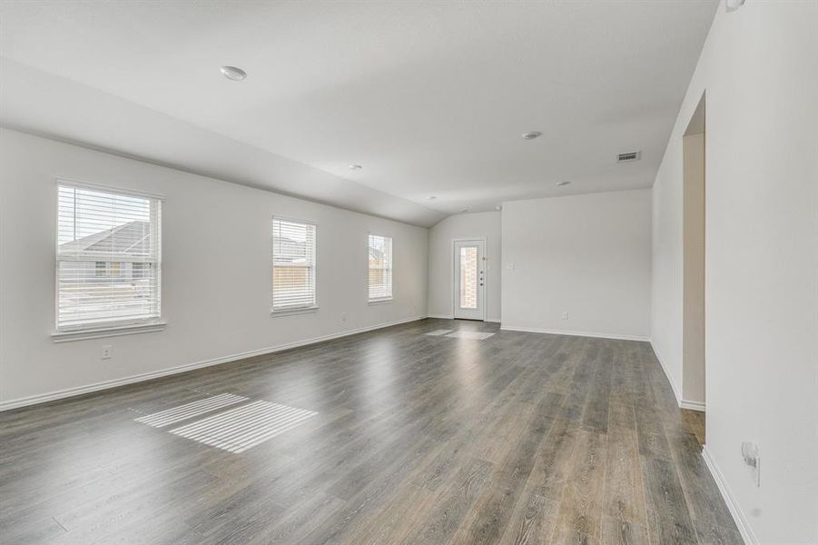 Empty room with dark hardwood / wood-style floors and plenty of natural light