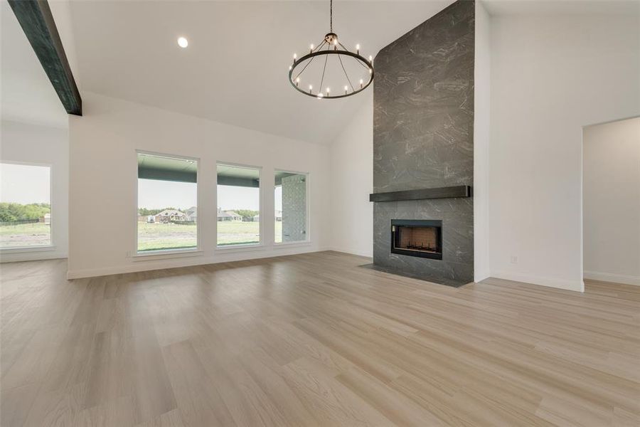 Unfurnished living room featuring light hardwood / wood-style flooring, a wealth of natural light, and a tile fireplace