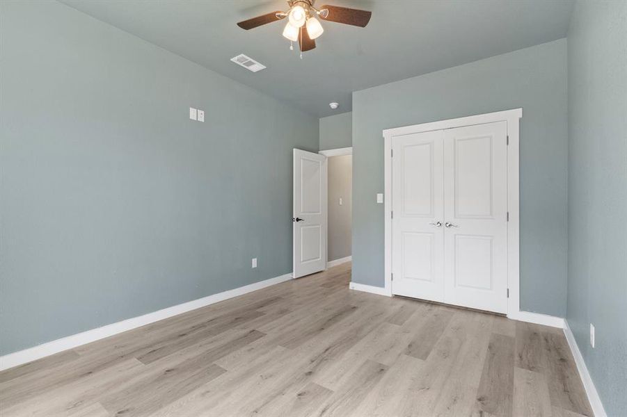 Unfurnished bedroom with a closet, ceiling fan, and light hardwood / wood-style floors