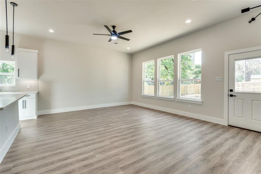 Unfurnished living room with ceiling fan and light wood-type flooring