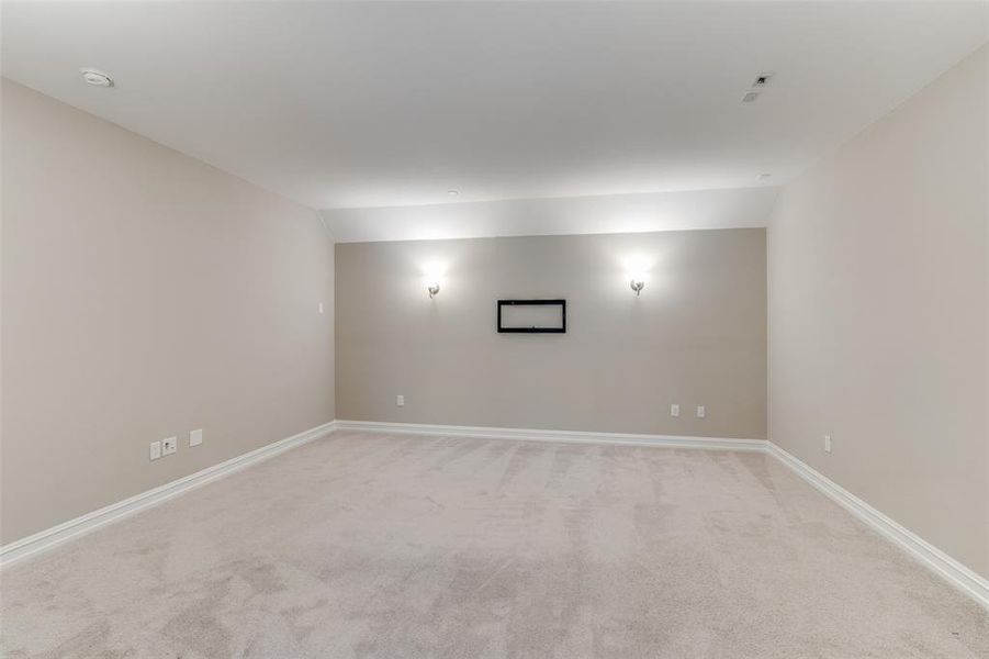 Spare room featuring lofted ceiling and light carpet