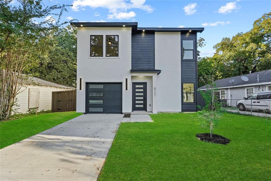 Modern home featuring a front yard and a garage