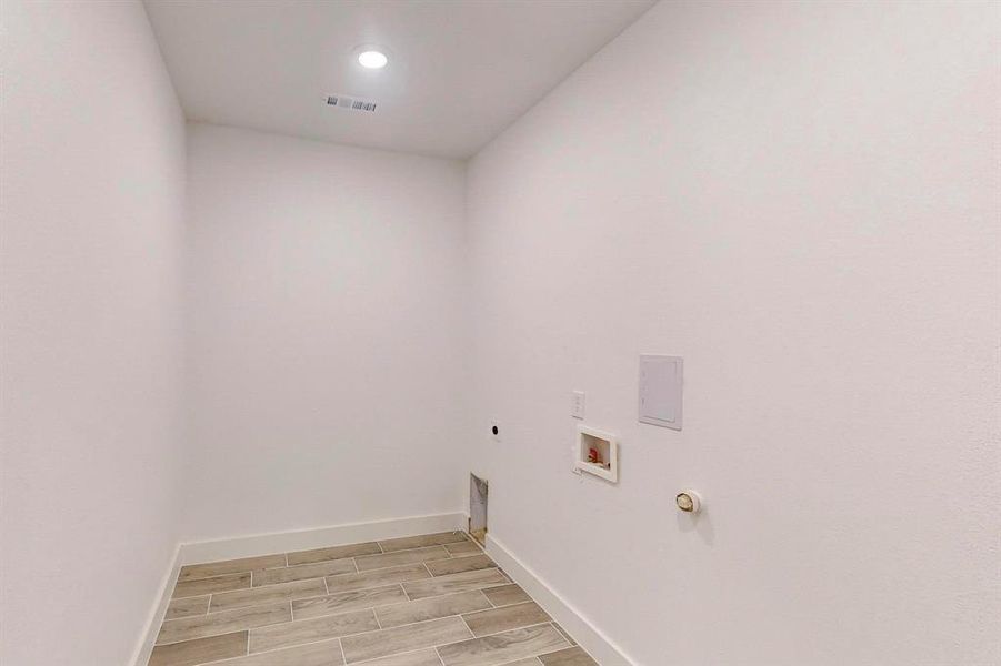 Laundry area featuring gas dryer hookup, electric dryer hookup, washer hookup, and light hardwood / wood-style flooring