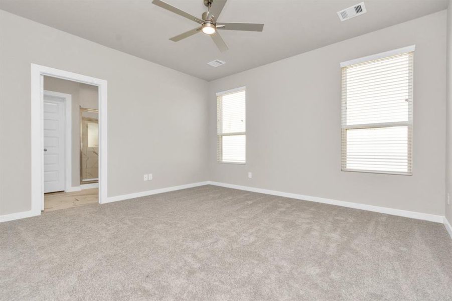 Come decompress in the stunning primary suite after a lengthy day! Experience the luxury of plush carpeting, warm paint hues, high ceilings, and large windows featuring privacy blinds. Sample photo of completed home with similar floor plan. As-built interior colors and selections may vary.