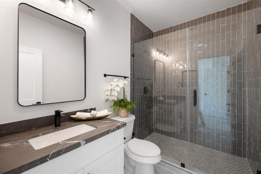 This secondary bath features a glass enclosed shower.