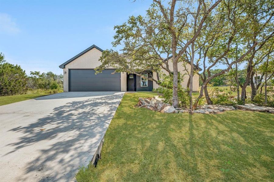 View of front of house featuring a front lawn and a garage