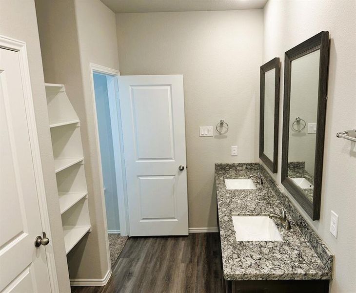 Double sinks in the en suite master bath + linen shelves, granite counters & framed mirrors!