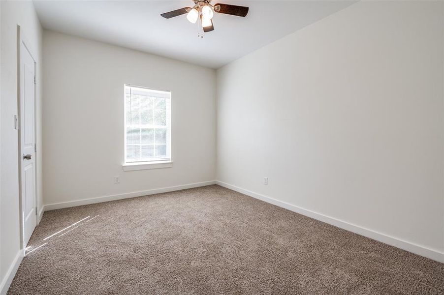 Carpeted empty room with ceiling fan