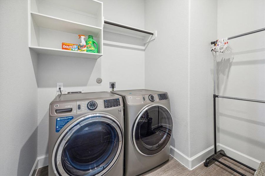 Having space for a full-size washer and dryer in the utility room is a convenient feature that simplifies laundry tasks. Additionally, the custom shelving provides extra storage and organization options, making it easier to keep laundry essentials neatly arranged.