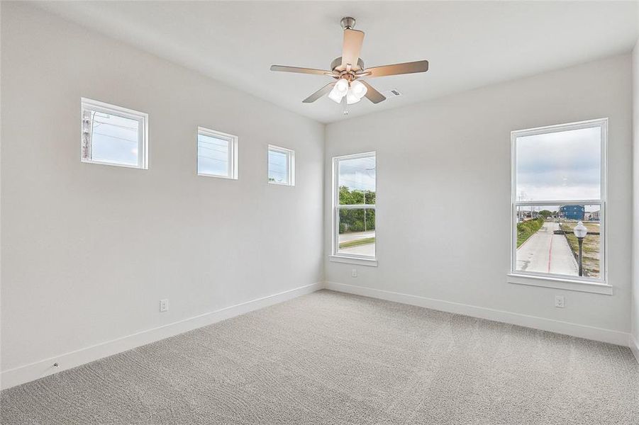 Carpeted empty room featuring ceiling fan