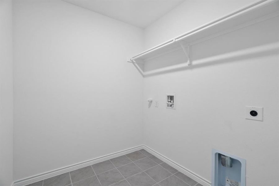 Clothes washing area featuring hookup for a washing machine, hookup for a gas dryer, tile patterned flooring, and hookup for an electric dryer