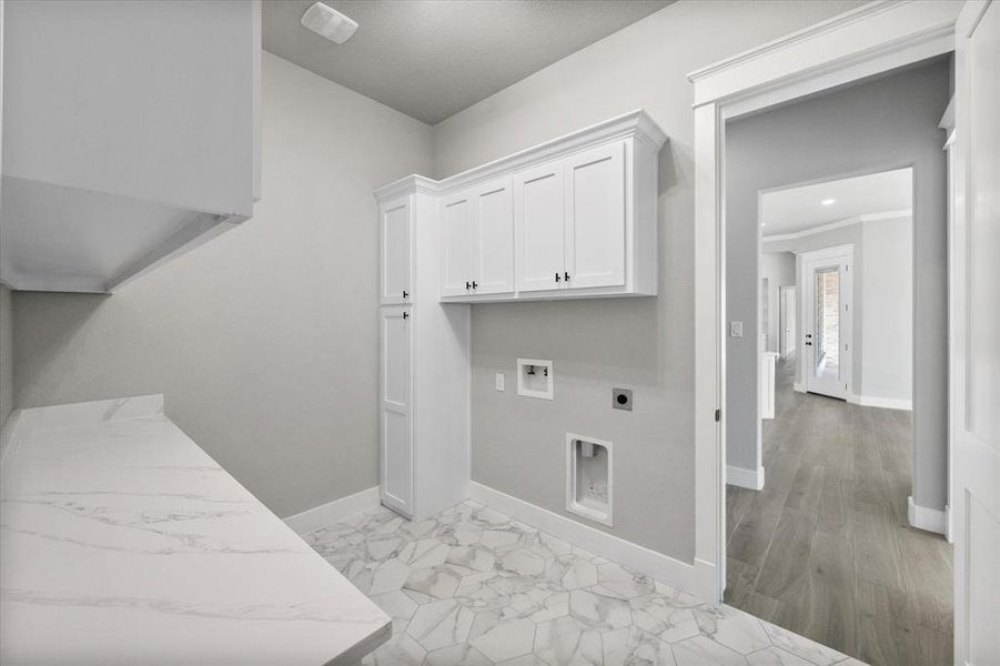 Clothes washing area featuring hookup for a washing machine, light hardwood / wood-style flooring, cabinets, and electric dryer hookup