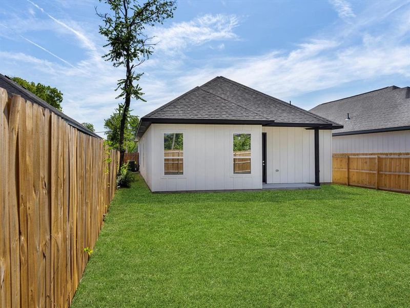 Back of house with a lawn