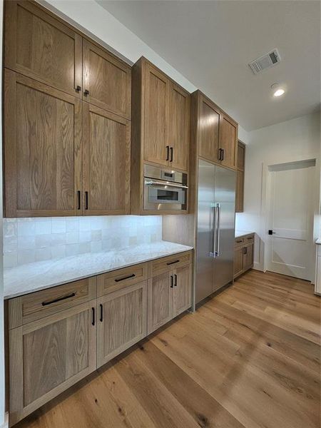 Premium White Oak cabinets with counter depth 48in Thermador Fridge and built-in microwave