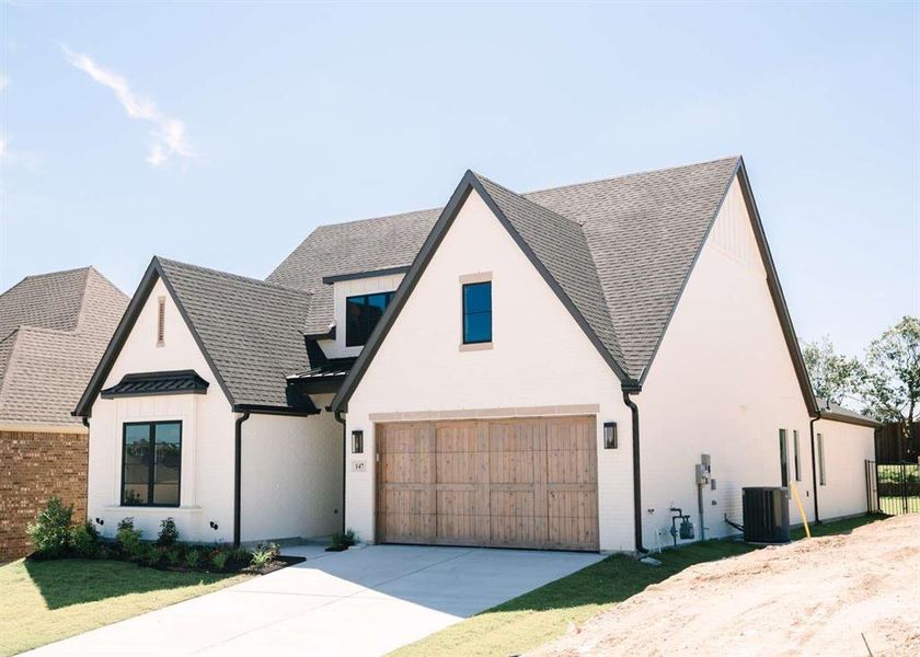 Modern inspired farmhouse featuring cooling unit and a garage