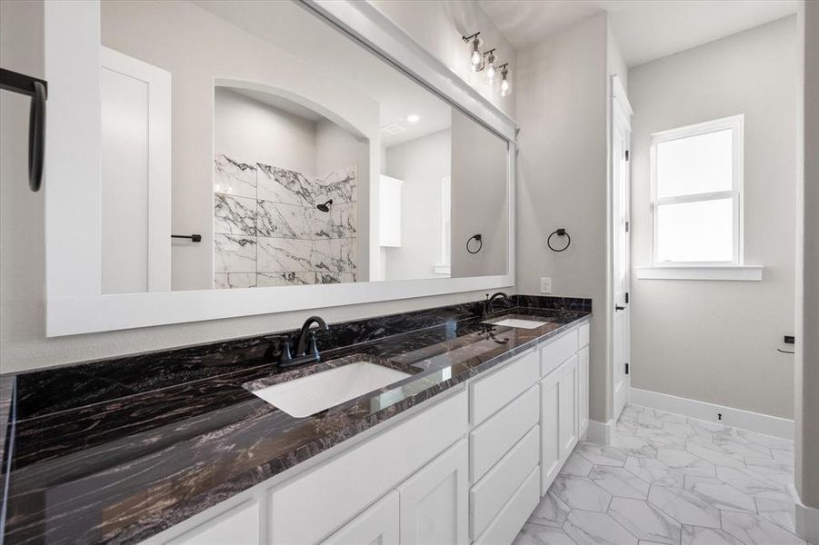 Bathroom featuring vanity and tiled shower