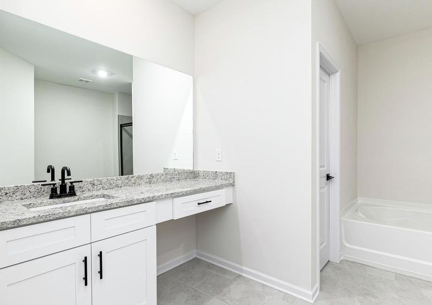 The master bathroom has a built in vanity area, as well as a separate bathtub and shower