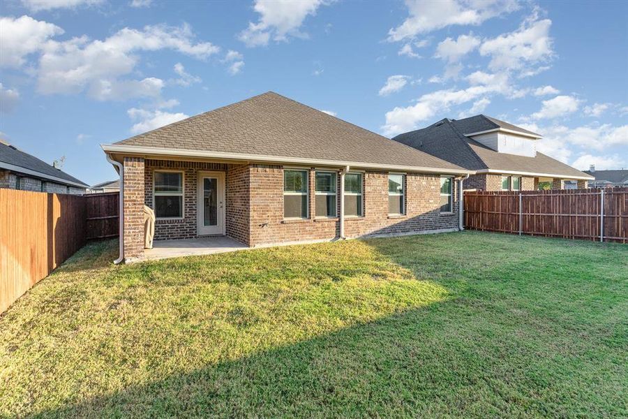 Back of property with a patio area and a lawn