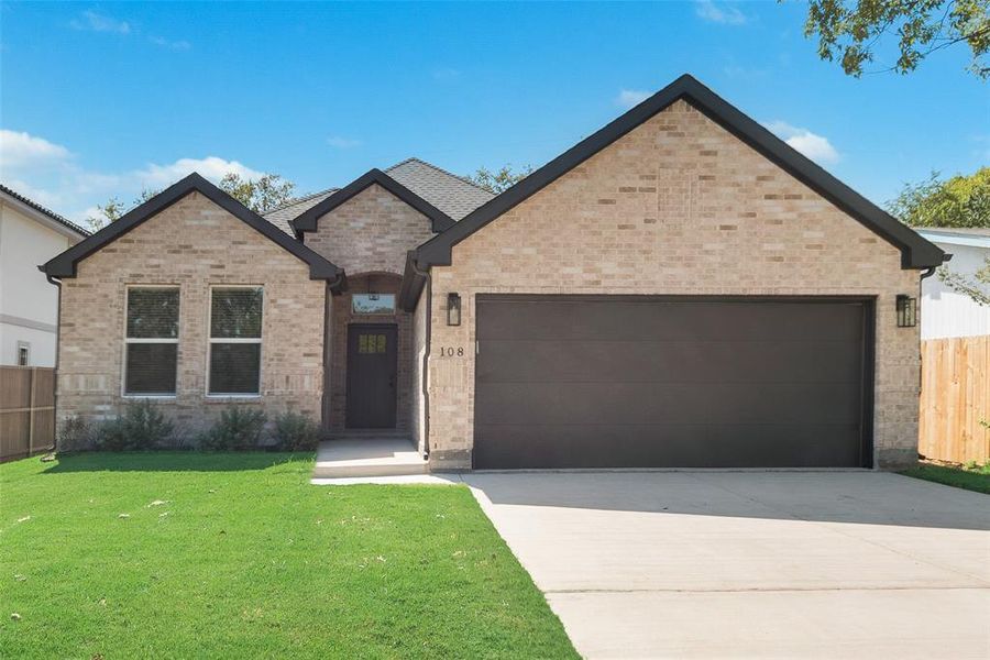 View of front facade with a front lawn and a garage