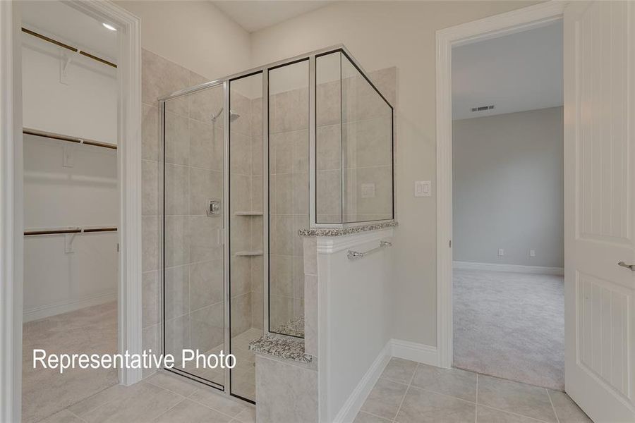 Bathroom with tile patterned floors and a shower with shower door