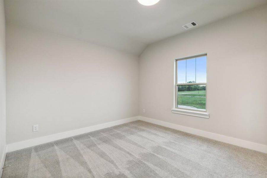 Spare room with light colored carpet and vaulted ceiling