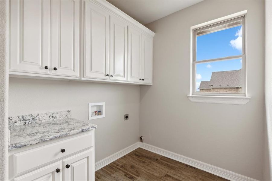 Laundry room featuring cabinets, electric dryer hookup, washer hookup, and dark hardwood / wood-style flooring