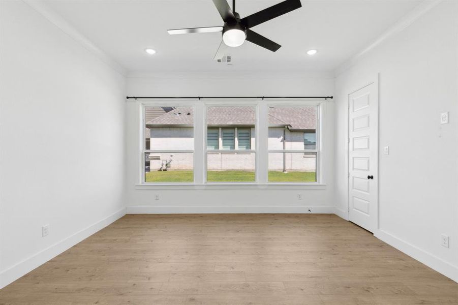 Unfurnished room with ceiling fan, light hardwood / wood-style flooring, crown molding, and a healthy amount of sunlight