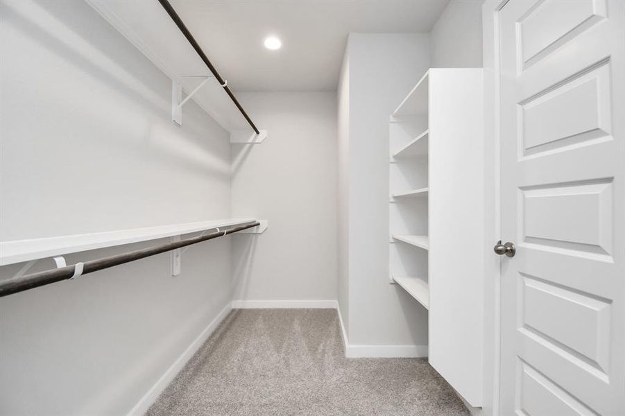 Spacious primary walk in closet with built ins. Sample photo of completed home with similar plan. Actual color and selections may vary.