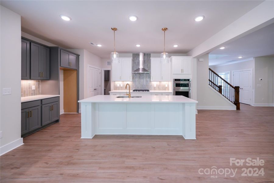 Modern kitchen with Barnett Linen and Boulder painted cabinets with gold hardware