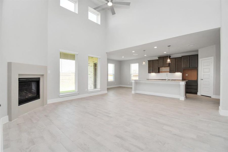 Bring your loved ones and guests together in the inviting living room! Boasting lofty high ceilings, recessed lighting, a stylish ceiling fan, custom paint, stunning flooring, and expansive windows that flood the space with ample natural light all day long.