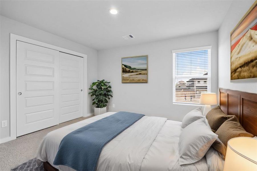 This secondary bedroom features custom paint, plush carpet, and a large window with privacy blinds!