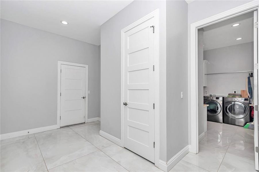 Garage entrance with half bathroom and laundry room