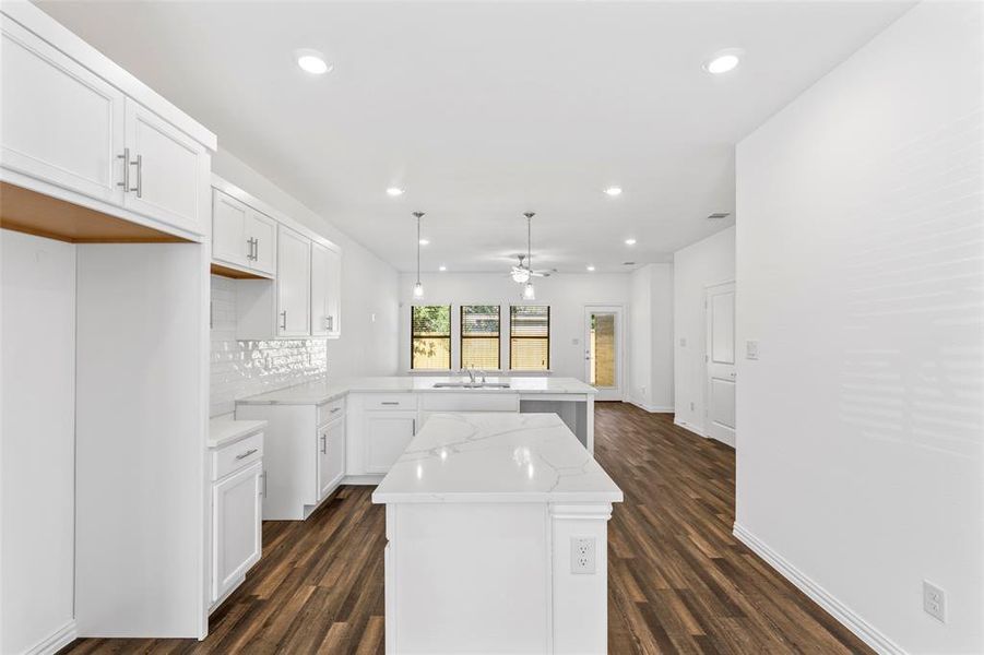 Kitchen featuring white cabinets, kitchen peninsula, dark hardwood / wood-style flooring, a center island, and ceiling fan