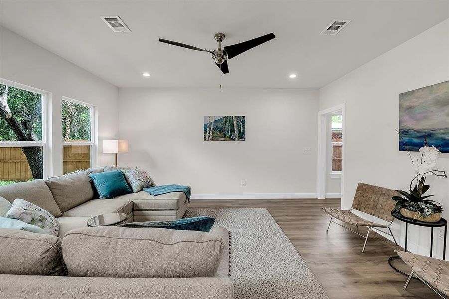 Living room with wood-style flooring and ceiling fan