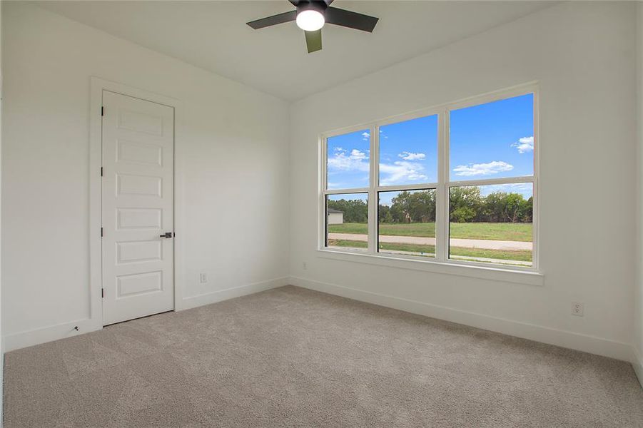 Carpeted empty room with ceiling fan