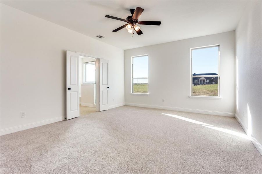 Carpeted empty room with ceiling fan