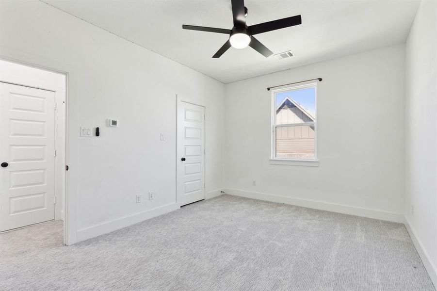 Carpeted spare room featuring ceiling fan