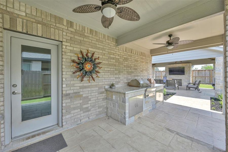 Just outside your back door you'll enjoy a back porch extension that comes complete with an integrated smoker/grill that has plenty of counter and storage space.  Notice the ceiling fans in this area, perfect to keep the cook cool during summer bbq coockouts.