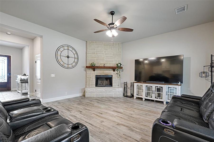 Living room featuring hardwood / wood-style flooring, a fireplace, and ceiling fan