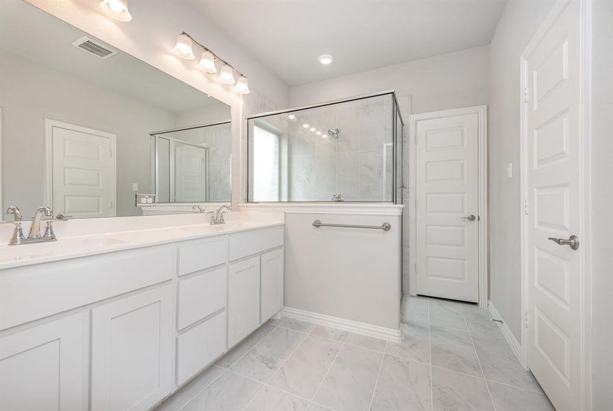 Bathroom with tile patterned floors, walk in shower, and dual bowl vanity