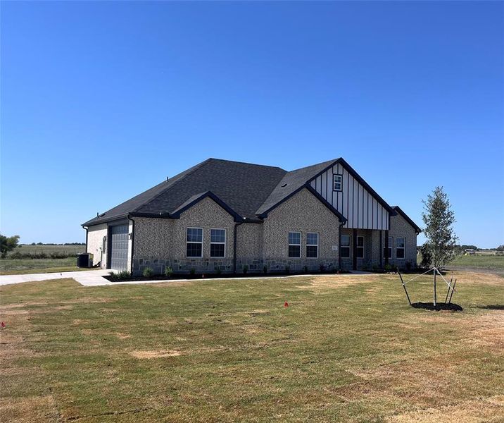 View of front of home with a garage and a front yard