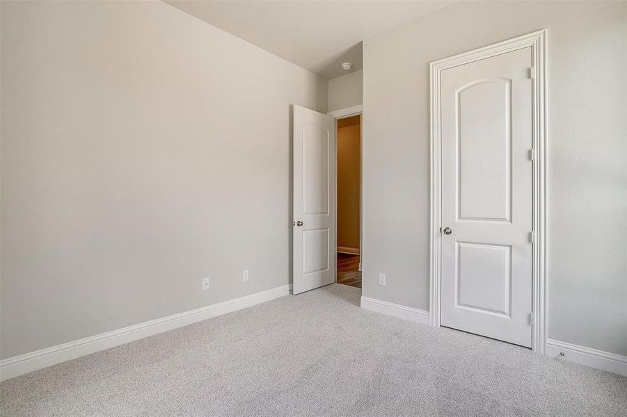 Unfurnished bedroom with light carpet