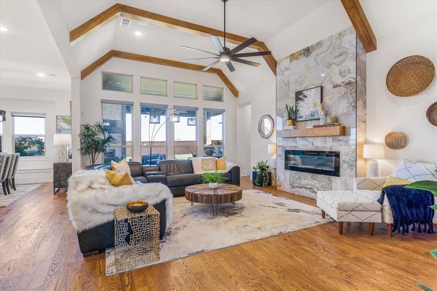 Living room with hardwood / wood-style flooring, high vaulted ceiling, and a healthy amount of sunlight