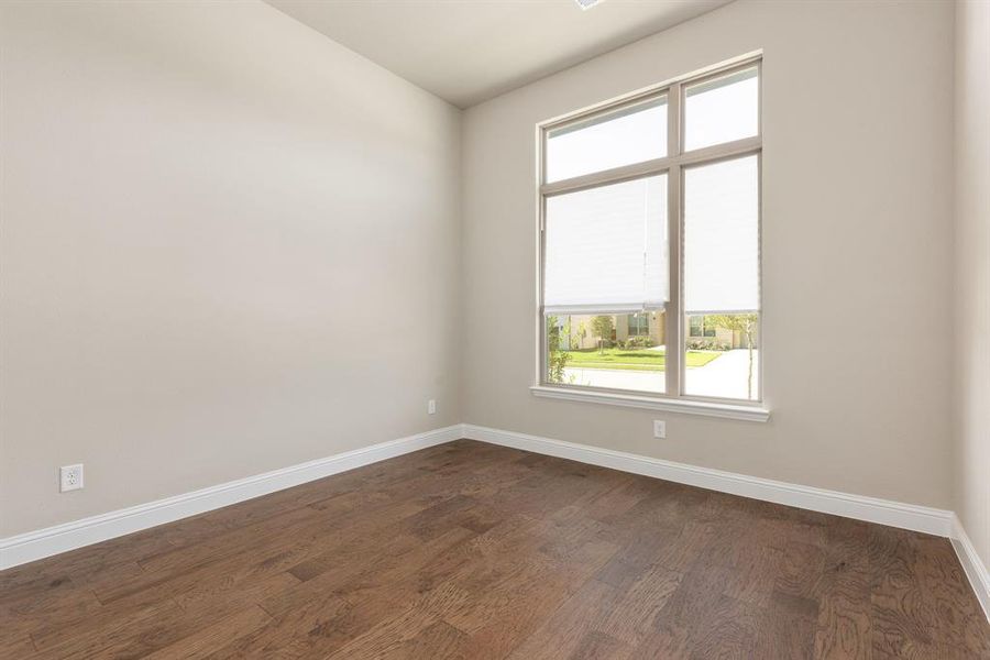 Spare room featuring dark hardwood / wood-style floors and a healthy amount of sunlight