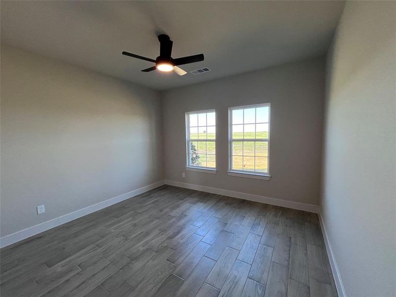 Empty room with light wood-type flooring and ceiling fan