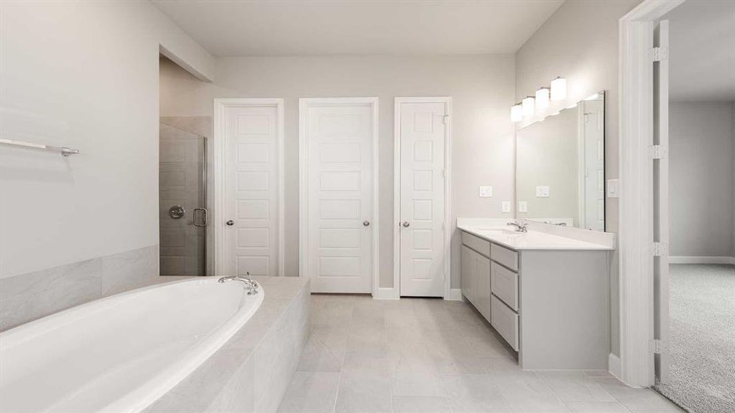 Bathroom featuring shower with separate bathtub, vanity, and tile patterned flooring