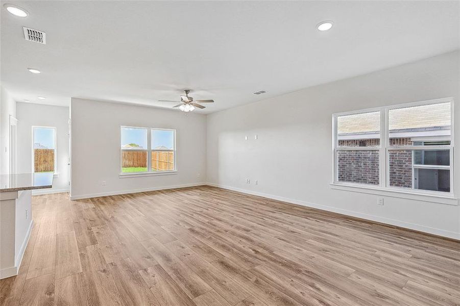 Unfurnished living room with ceiling fan and light wood-type flooring