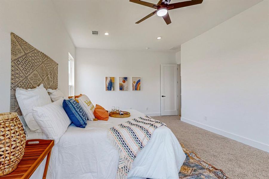 Main Carpeted bedroom featuring ceiling fan