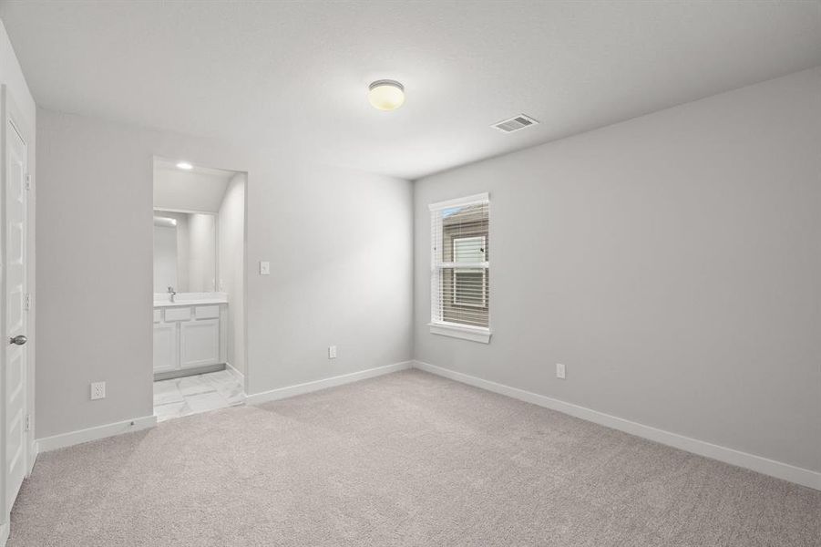 Secondary bedroom features plush carpet, custom paint, large window with privacy blinds and access to the Jack and Jill bath. Sample photo of completed home with similar floor plan.